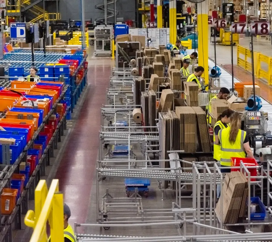 Warehouse staff managing automated packing stations