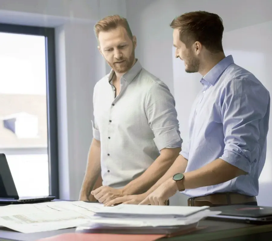 Two warehouse automation engineers collaborating in a modern office.