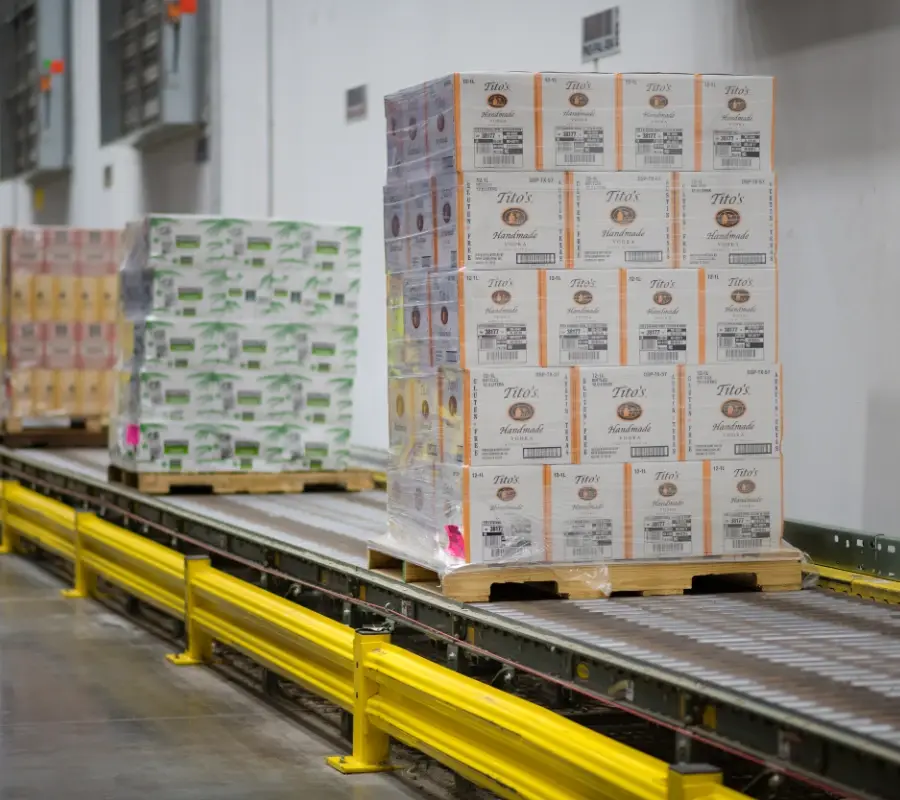 Pallets move on an automated conveyor system in a beverage distribution warehouse.