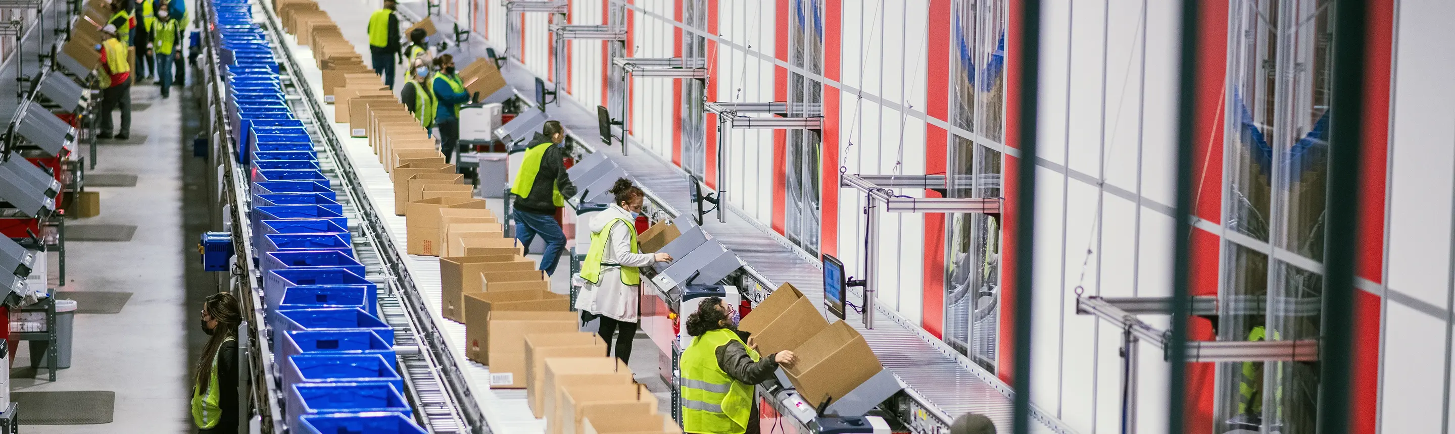 row of workers using automated picking system for order fulfillment at 3pl facility