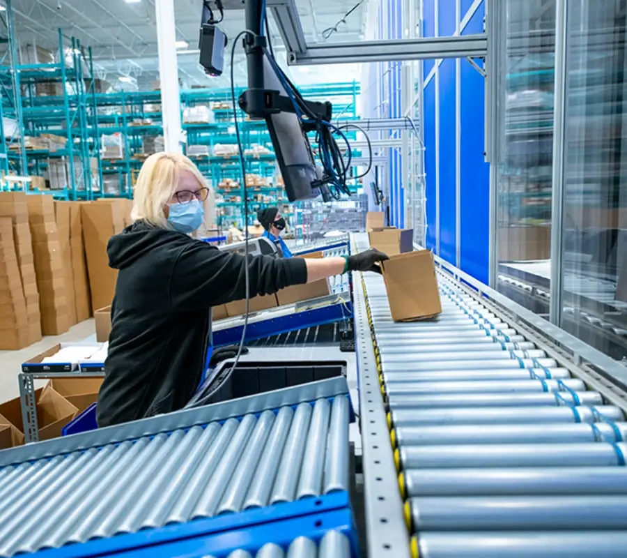 A warehouse worker uses automated equipment to process parts and components orders for distribution.