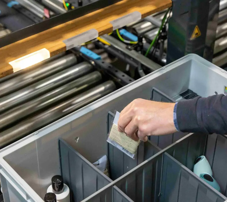A worker picks an item from a divided storage bin in an automated storage system